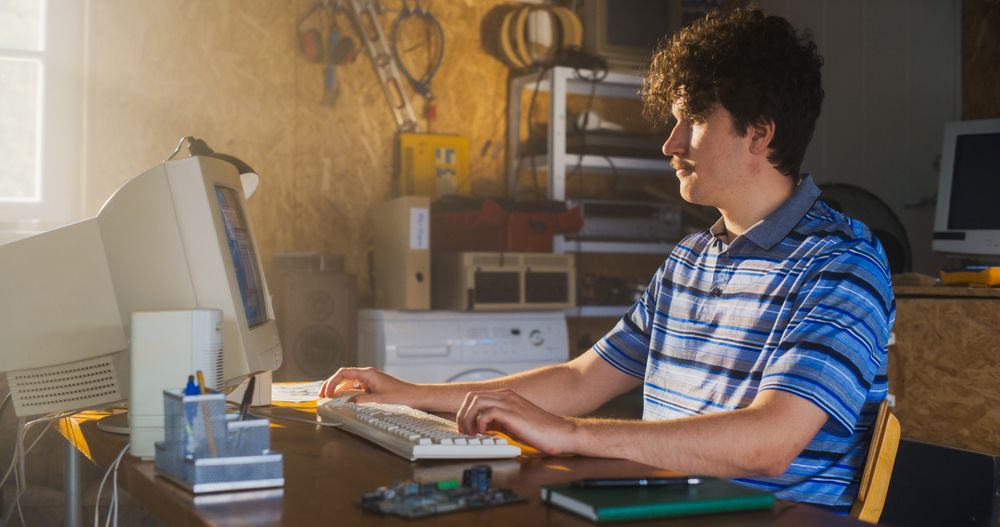 Male Software Engineer Programming On Old Desktop Computer In Retro Garage.