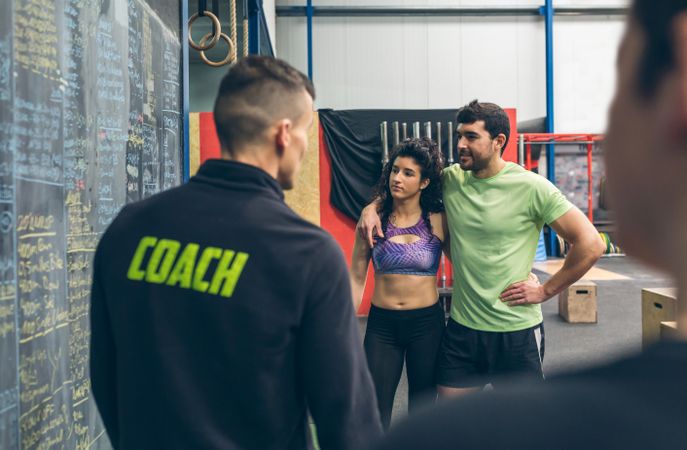 Couple with their coach in the gym