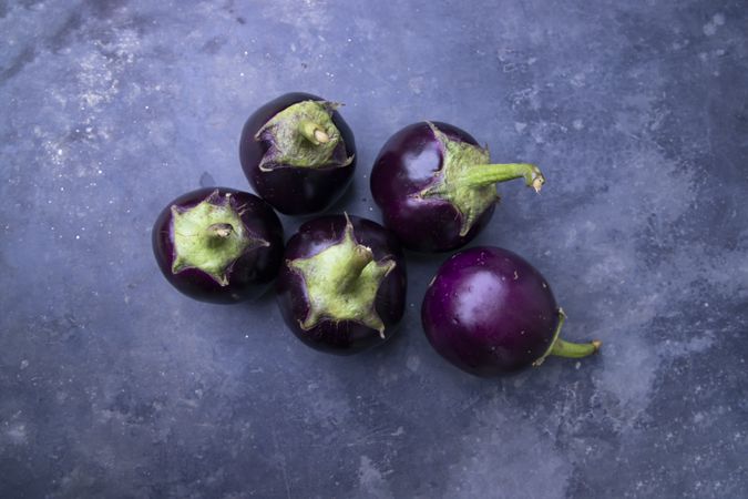 Small eggplants on a grey concrete floor