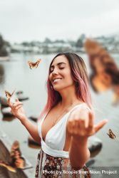 Smiling woman with brown butterflies flying over bYr3N0