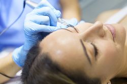 Female having eye lashed put on in salon