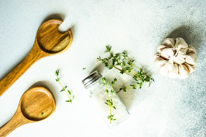 Salt and pepper shakers, thyme and garlic on grey counter with copy space