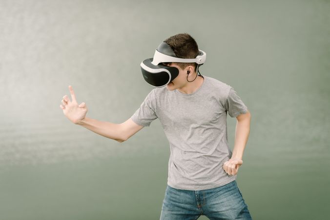 Young teenager with virtual reality glasses outdoors