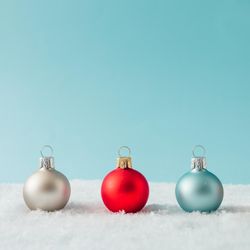Row of Christmas bauble decorations on snow