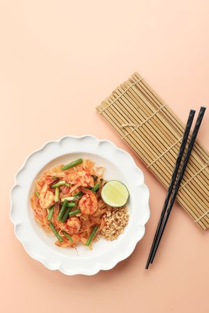 Top view of spicy pad Thai served with chopsticks