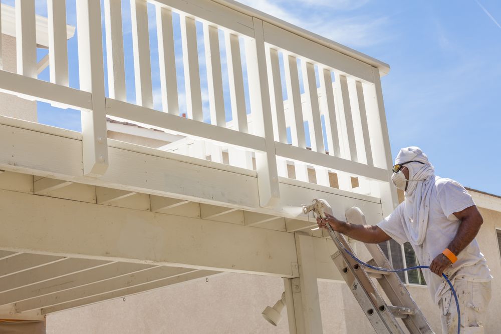 House Painter Spray Painting A Deck of A Home