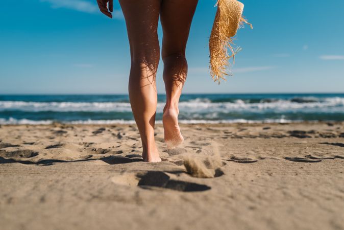 Woman legs on sandy beach