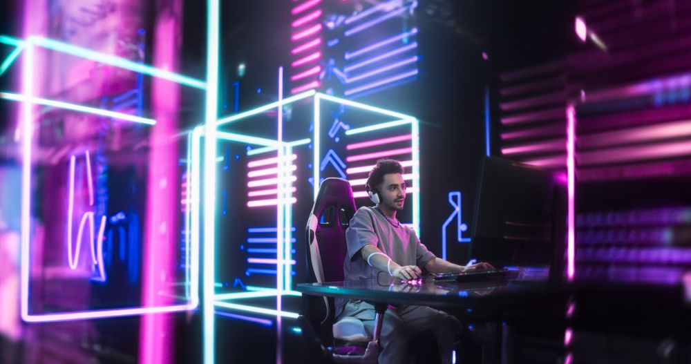 Young Handsome Gamer Playing Online Video Game on a Computer.