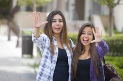 Female Students Carrying Backpacks on School Campus