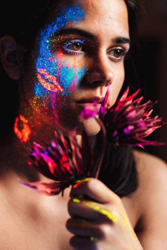 Young woman covered with uv painting