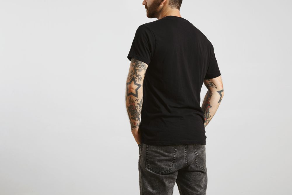 Rearview of bearded man in plain dark t-shirt and dark jeans