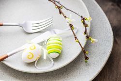 Table setting for Easter dinner with egg decor and branch