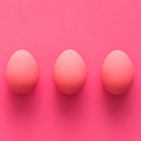 Row of three pink Easter eggs on pink background