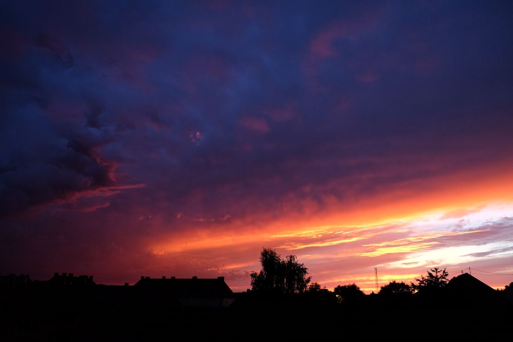Vibrant purple & yellow sunset over rooftops in France