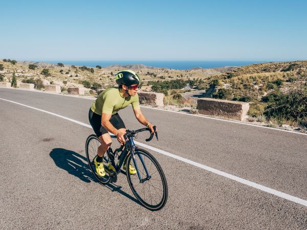healthy man riding a bicycle on a mountain road in a sunny day