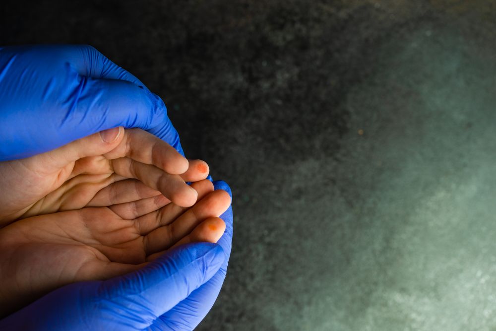 Top view of hands wearing purple latex gloves holding hands without gloves