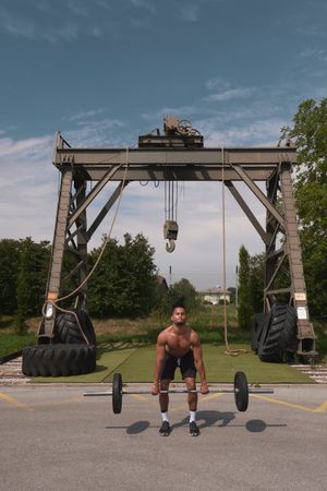 Black guy with barbell in outdoor gym