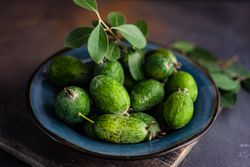 Blue plate of fresh organic fruit feijoa
