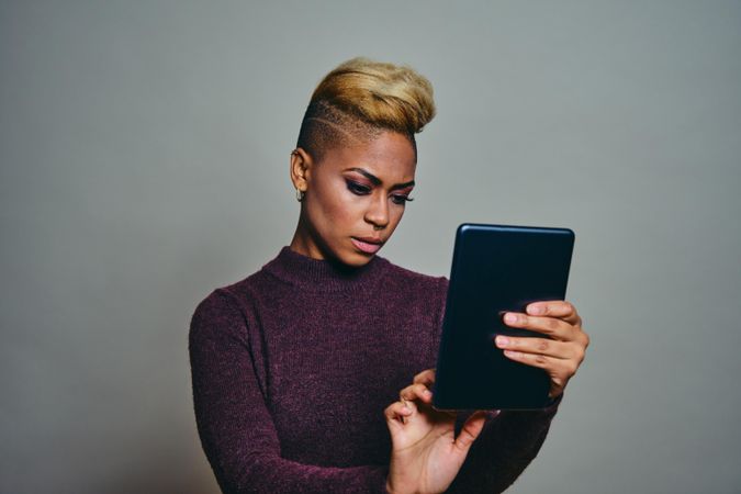 Black woman concentrating on a tablet