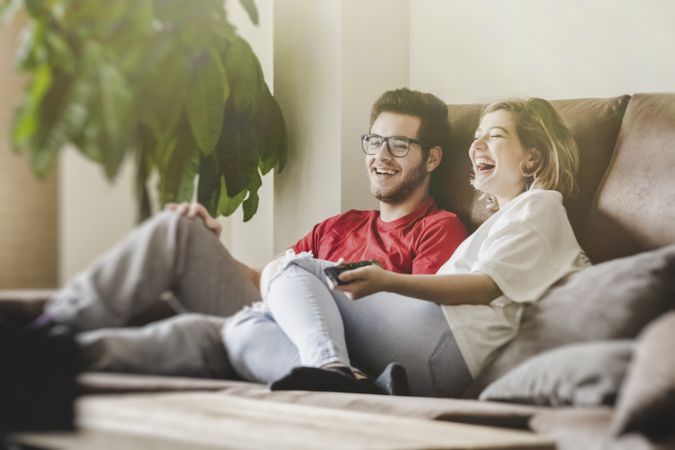 Happy couple watching TV on sofa