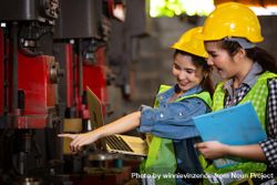 Two female engineers or technician worker wearing safety hard helmet in factory 5oypQb
