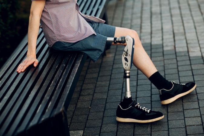 Man sitting on bench with prosthesis leg