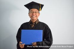 Happy and proud male graduate in studio shoot holding certificate 4BamZ3