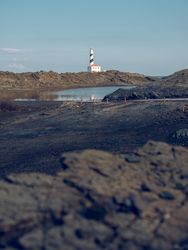 Lake and lighthouse in rocky terrain