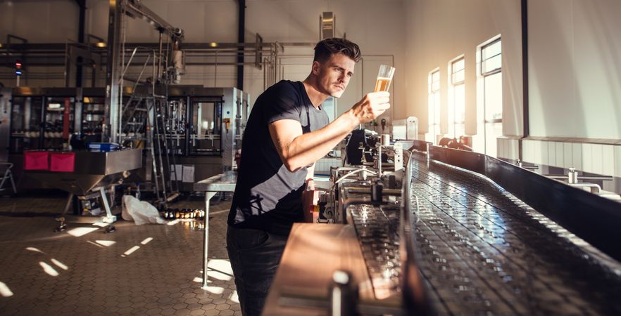 Brewery factory owner examining quality of craft beer