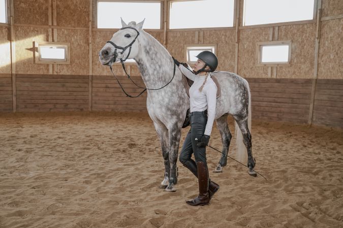 Rider with dapple gray horse in round arena