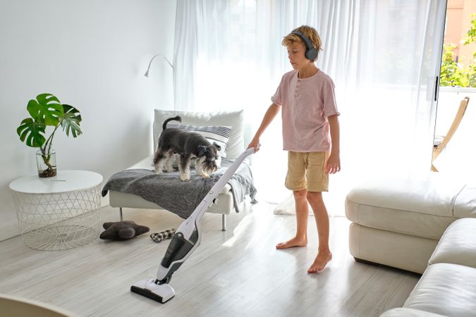 Boy cleaning light living room