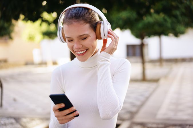 A Joyful Young Woman is Enjoying Music While Outdoors in the Fresh Air with Headphones on