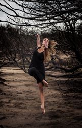 Woman dancing between dry trees