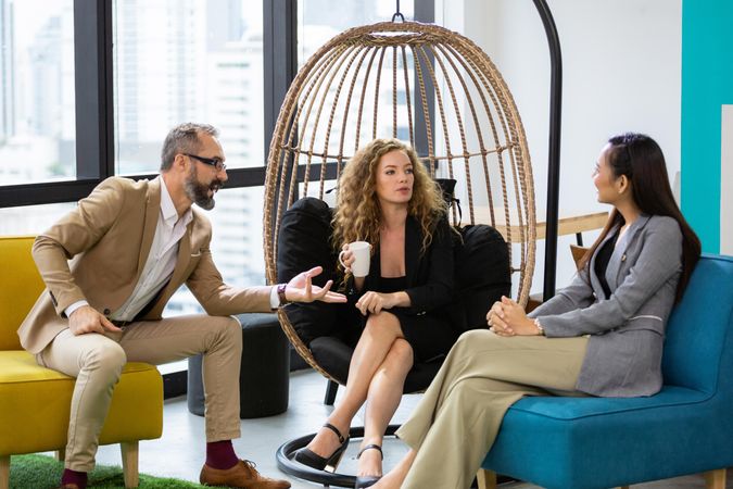 Group of businesspeople discussing work at couch in the office