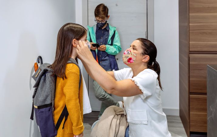 Mother putting the mask on her daughter