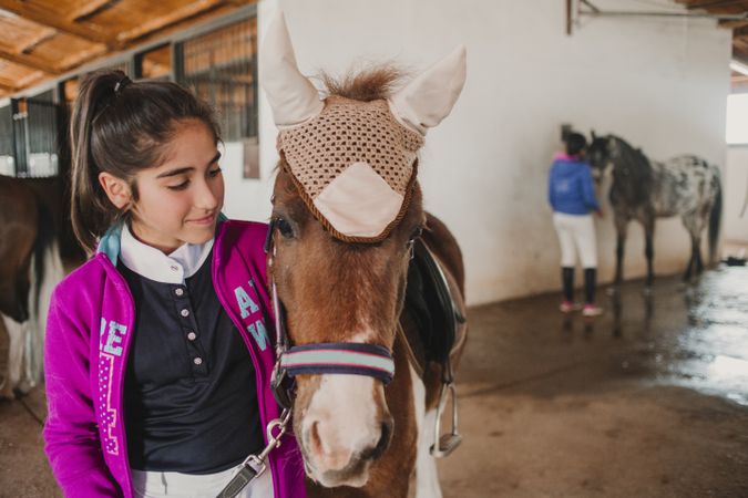 Girl with adorable pony in hat