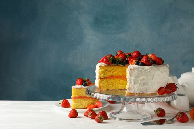Composition with delicious berry cream cake on wooden table. Tasty dessert