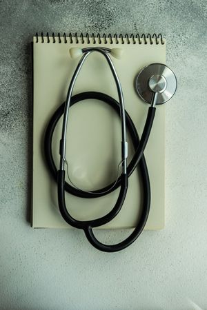 Stethoscope and notepad on marble counter