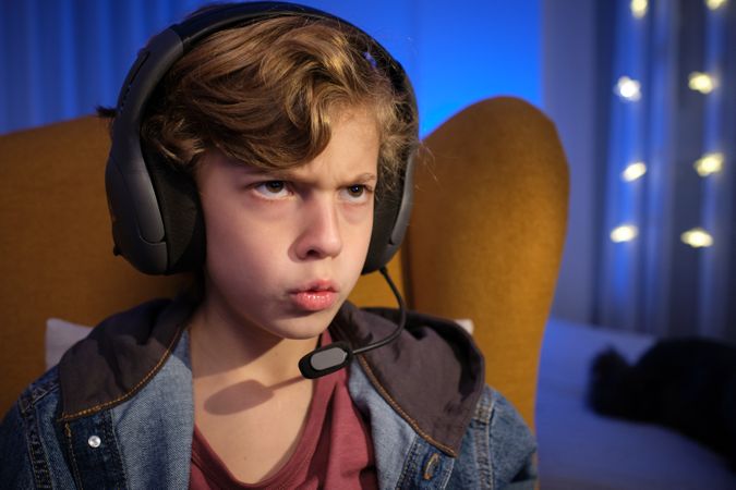 Serious boy in headphones with microphone
