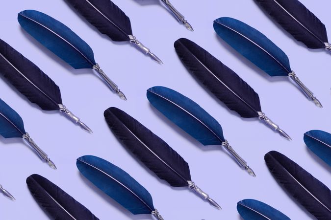 Blue quill pens on lavender background