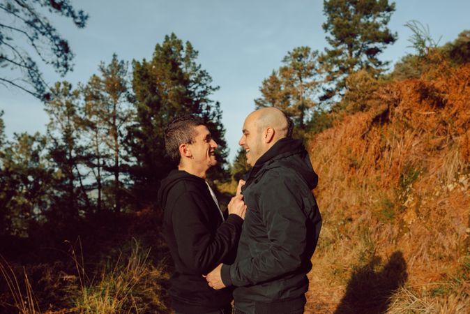 Men hugging and kissing in park