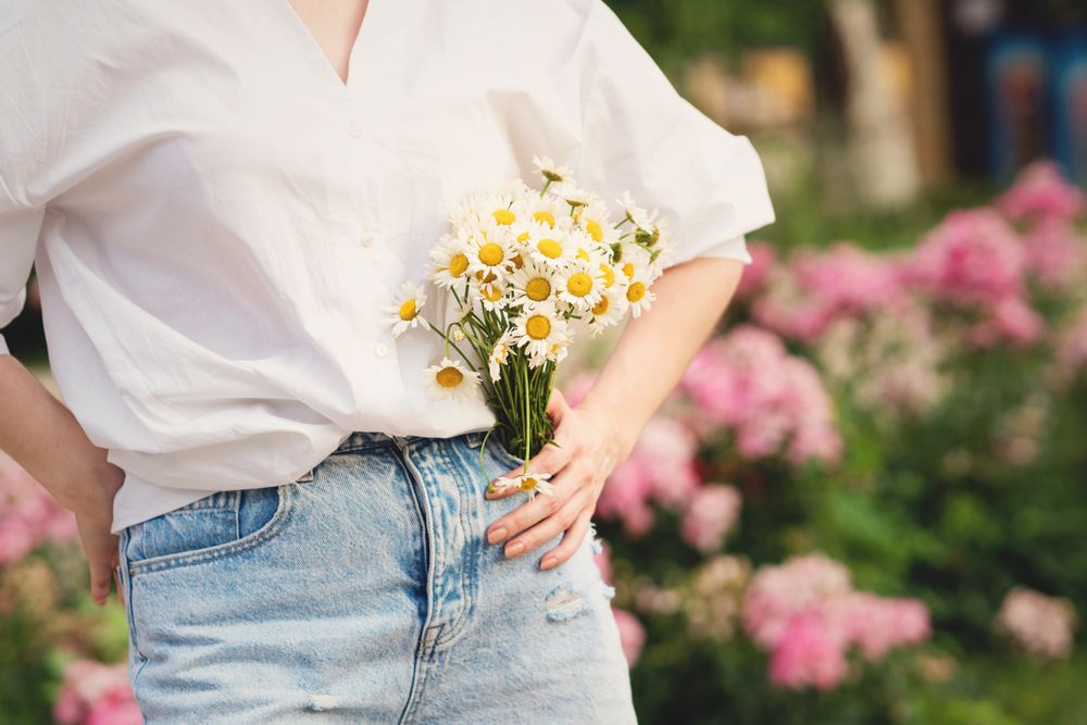 Woman with a bouquet of chrysanthemums. Background flowers