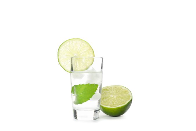 Tequila shot with lime, mint and ice isolated on blank background