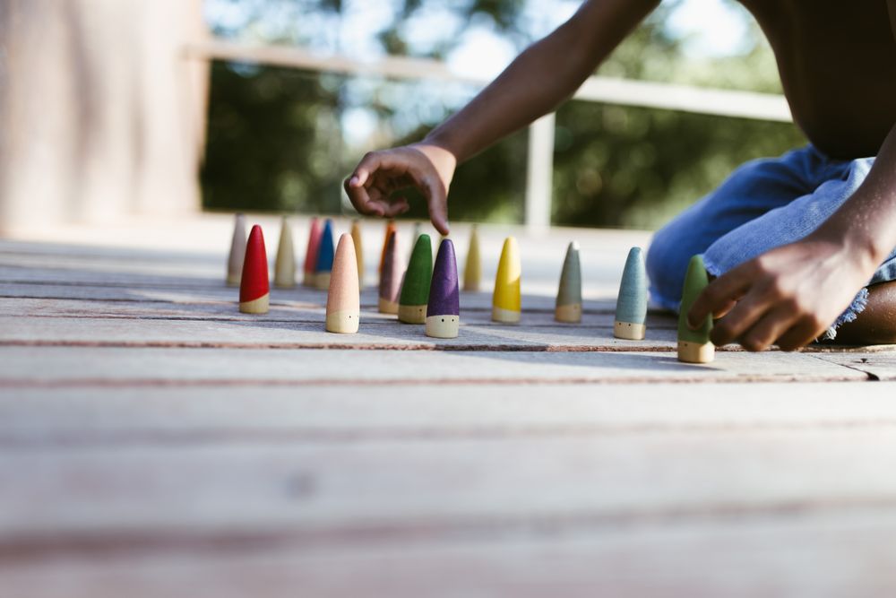 Crop Black kid playing with cones