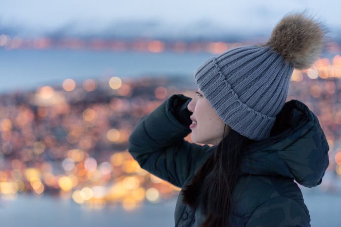 Joyful millennial woman enjoying view of night city