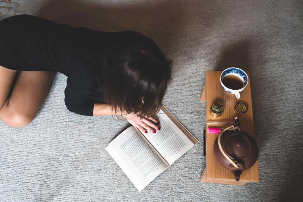 Female relaxing with a book and cannabis products