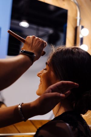 Makeup artist doing makeup for young female artist
