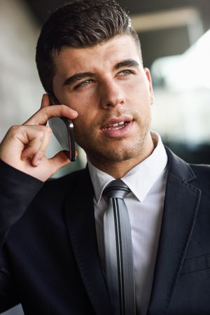 Portrait of man with blue eyes in suit and tie on phone
