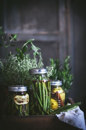 Fresh green vegetables with fruits and glass jars
