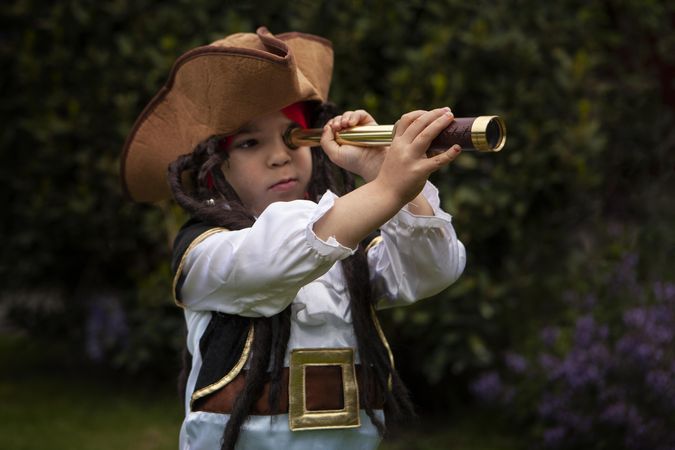 Girl wearing pirate outfit and holding a telescope